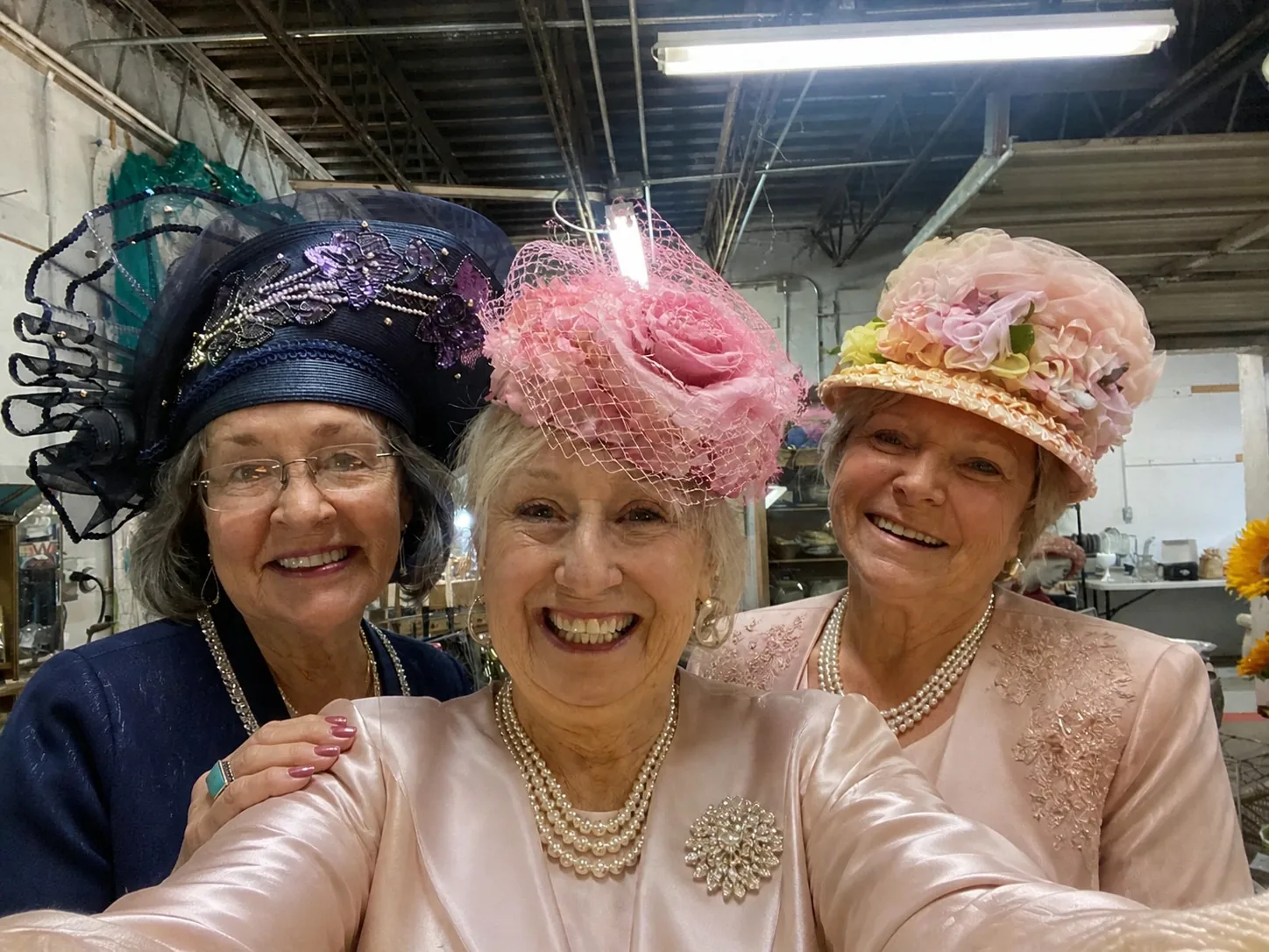Three friends smiling in festive hats