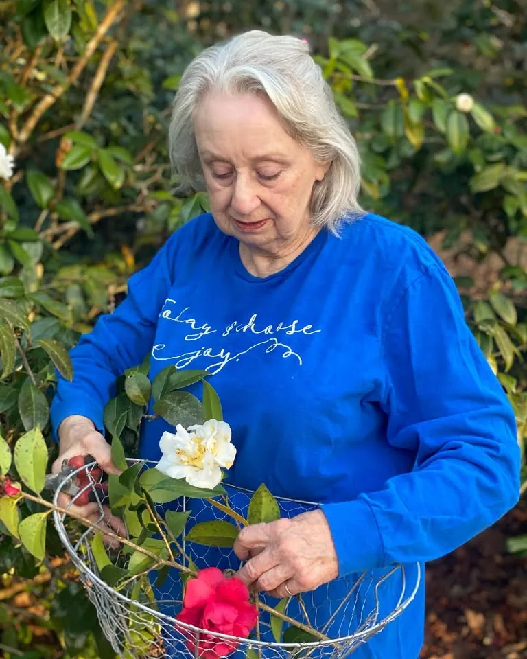 Brenda Gantt gathering flowers into a basket