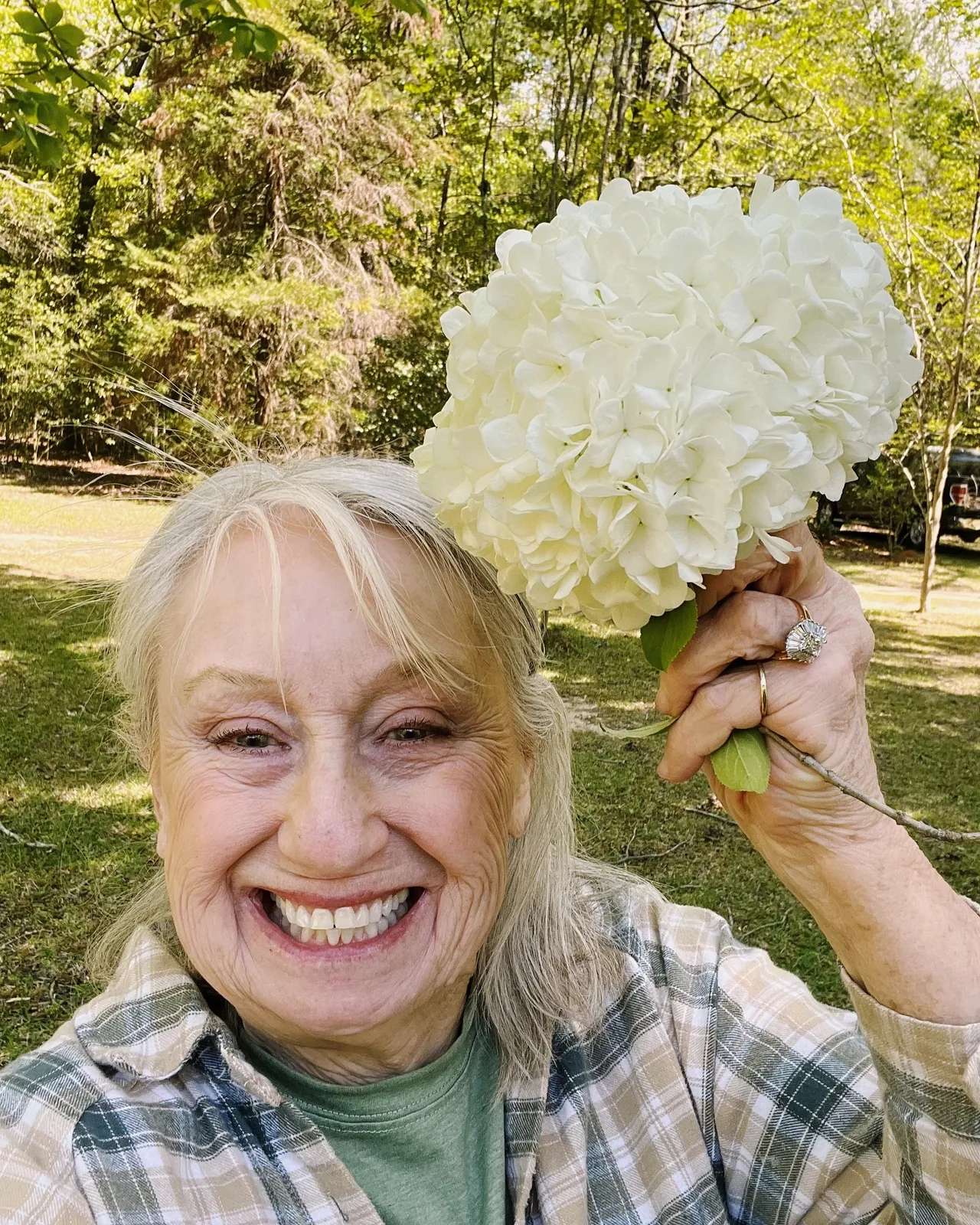 Brenda Gantt smiling beside a hydrangea bloom